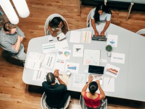 how to choose the right digital agency for your startup, A diverse group working on marketing strategies with charts and laptops in an office setting.